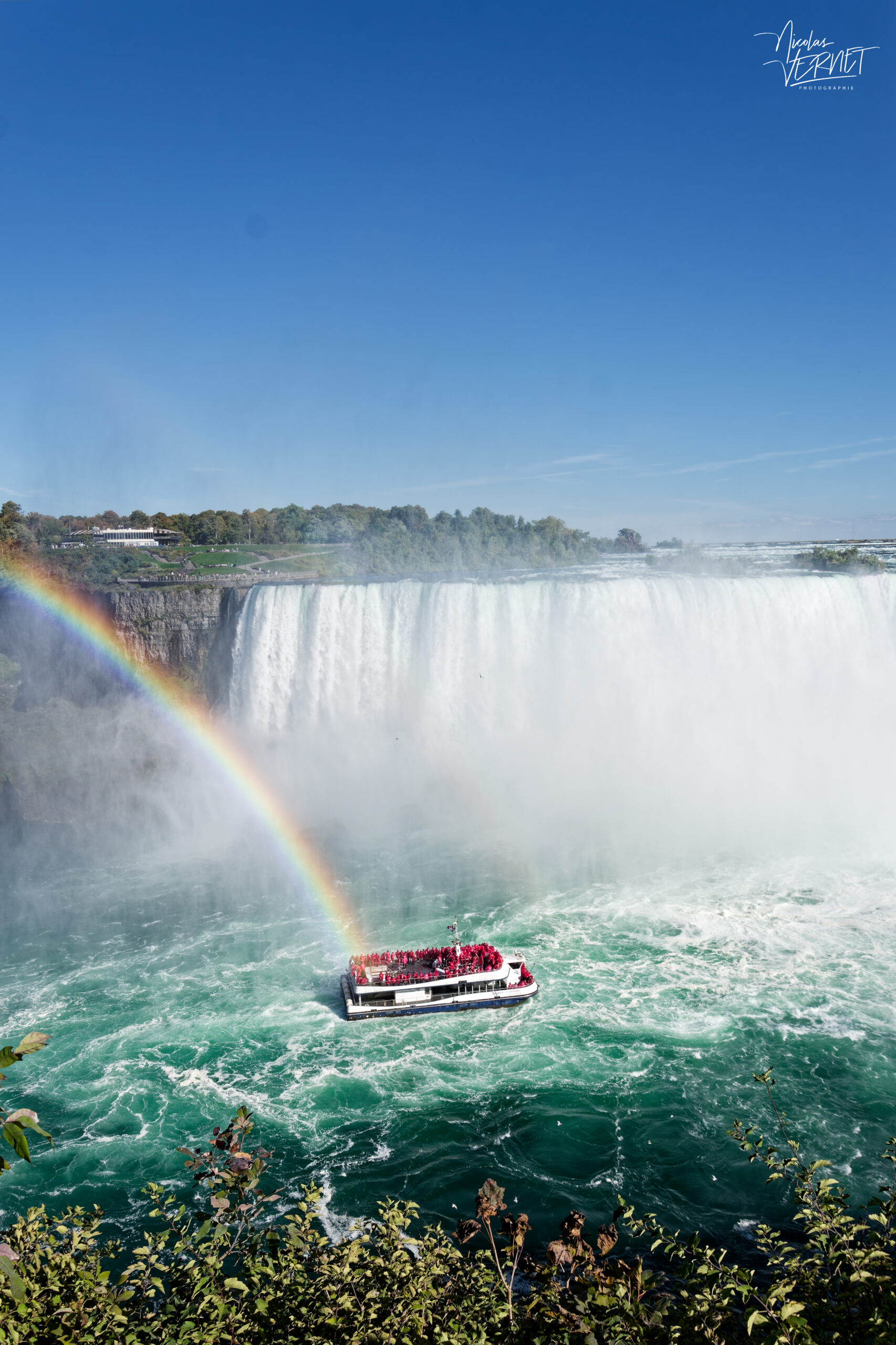 Arc-en-ciel et bateau de tourisme au pied des chutes du Fer-à-Cheval (Horseshoe Falls). Niagara Falls, Canada