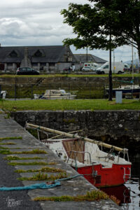 Voilier rouge, démâté, amarré dans le port de Galway, Irlande