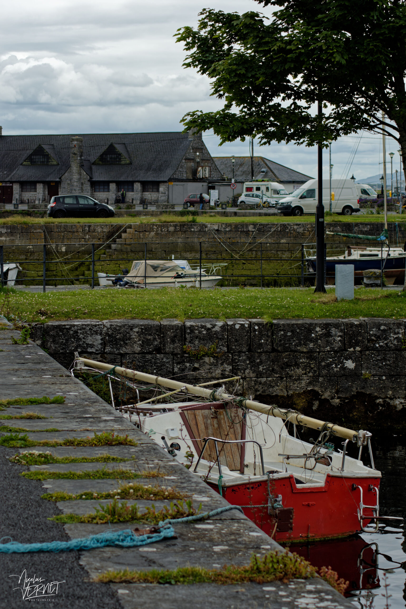 Voilier rouge, démâté, amarré dans le port de Galway, Irlande