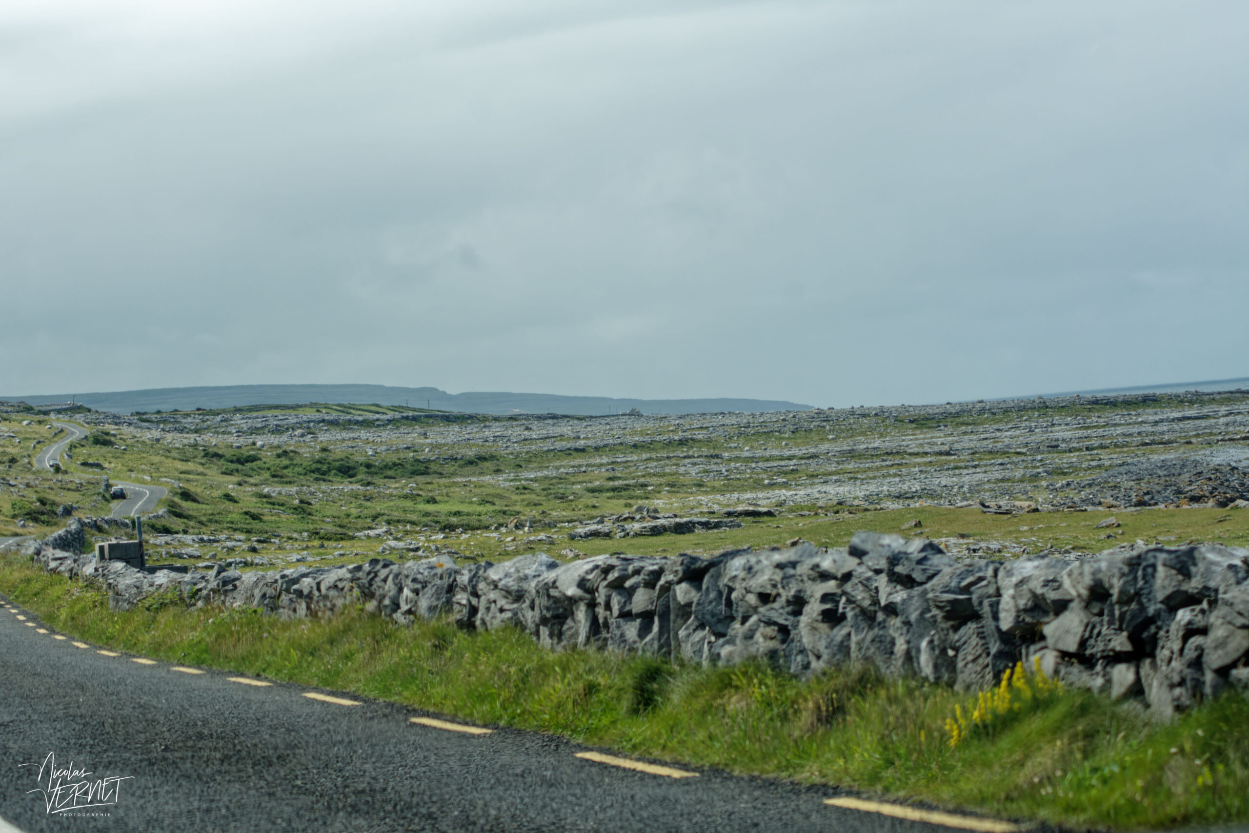 Route sinueuse qui traverse l'immense plateau calcaire du Burren, Co. Clare, Irlande